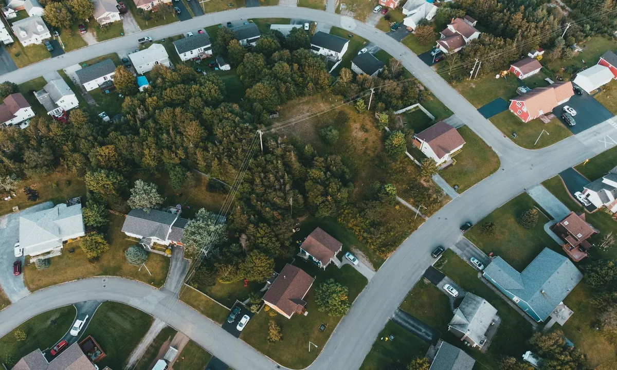 Aerial view of homes, wooded lots, and curving residential streets